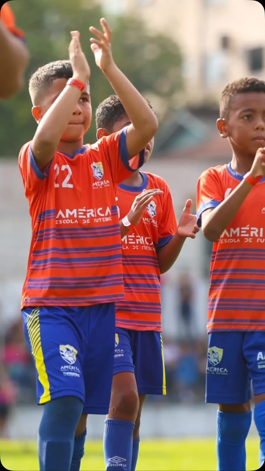 Alunos da América de uniforme laranja aplaudindo a torcida na Fla Cup 2026